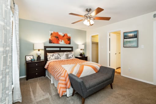 a bedroom with a large bed and a ceiling fan  at Lake Johnson Mews, North Carolina