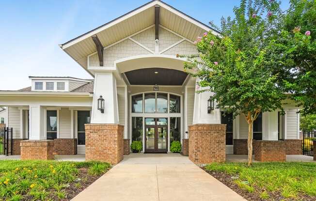 the view of the front of a building with a sidewalk and trees