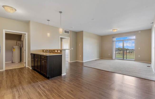 A spacious living room with a kitchen area in the background.