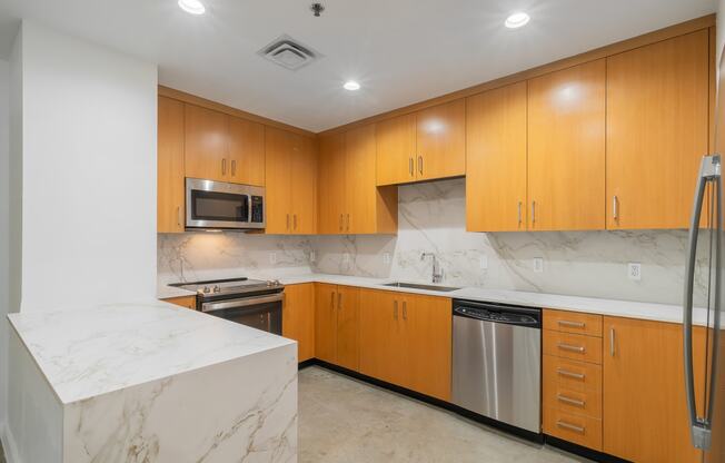 a kitchen with marble counter tops and wooden cabinets