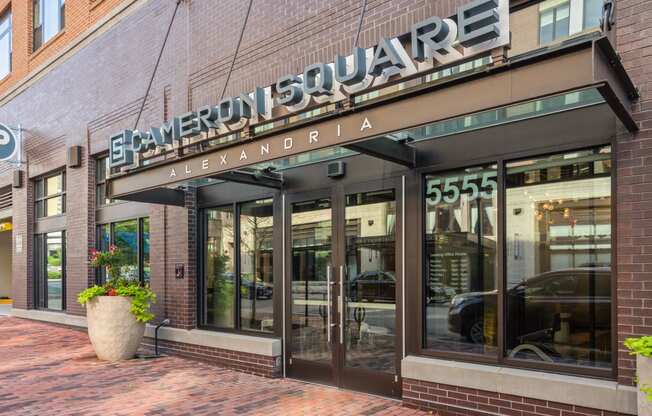 a store front of a brick building with glass windows and a sign on the front