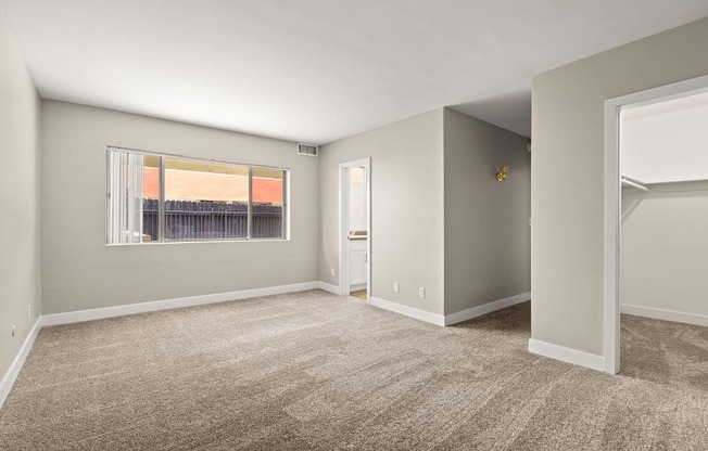 an empty bedroom with a large window