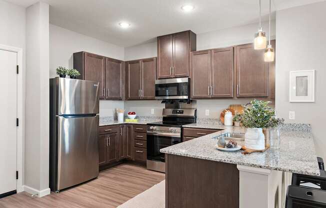 A kitchen with brown cabinets and a stainless steel refrigerator.