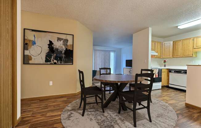 Fargo, ND Flagstone Apartments. a dining area with a table and chairs and a kitchen in the background
