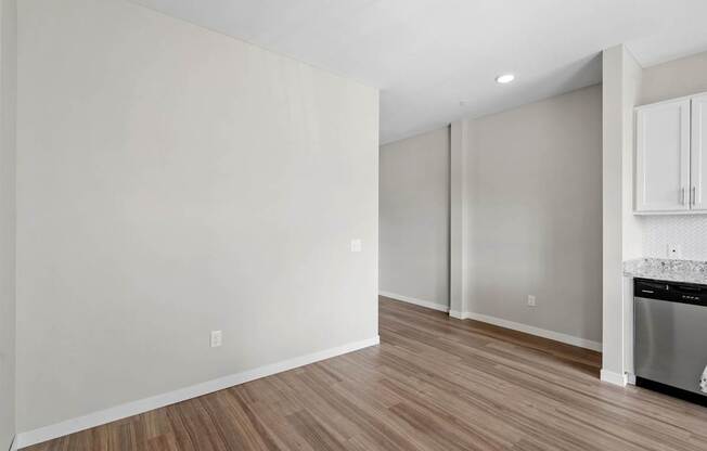 A kitchen with white cabinets and a wooden floor.