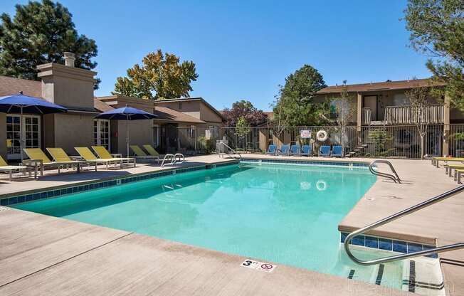 A large swimming pool with a slide and sun loungers.