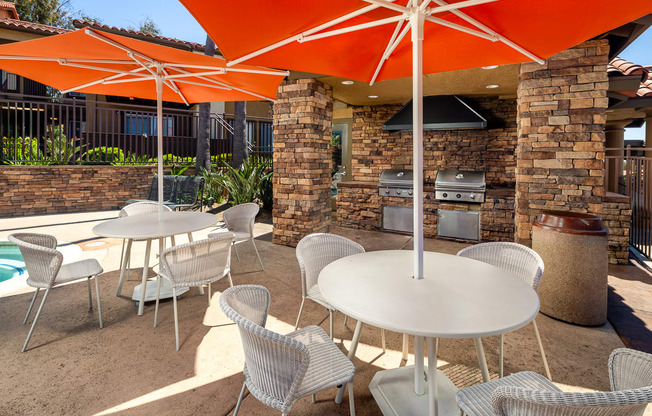 a patio with tables and chairs and umbrellas