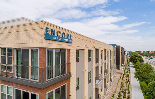 Elegant wood and white brick exterior at Encore Boulevard One Apartments, 7108 E Lowry Boulevard, CO