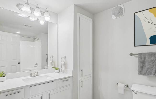 A bathroom with a white sink and a white toilet.