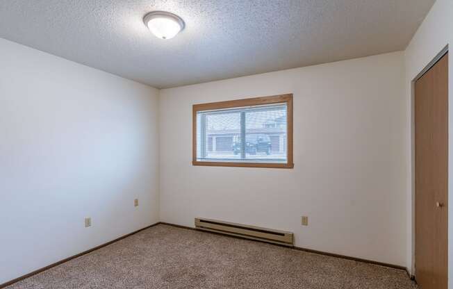 a bedroom of an empty house with a window. Fargo, ND Parkwood