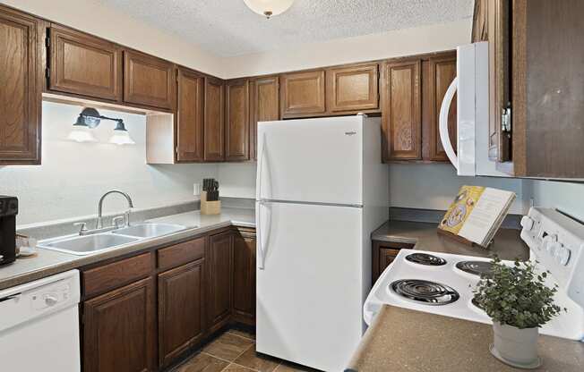 a kitchen with white appliances and wooden cabinets