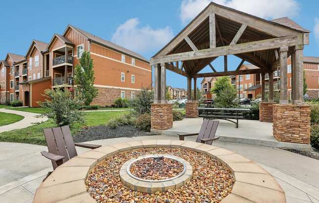 a fire pit with two chairs in front of a building