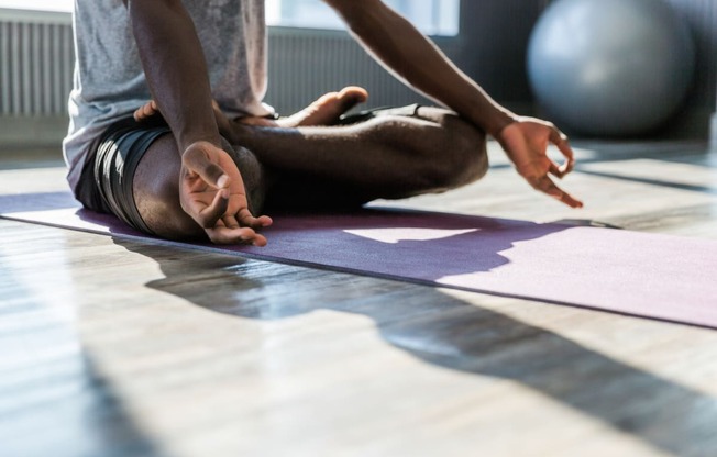 a person doing yoga on a purple mat on the floor