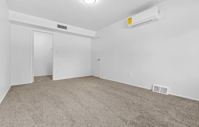 a bedroom with white walls and carpet