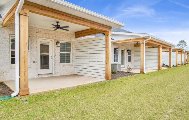 the front of a house with a porch and a grass yard