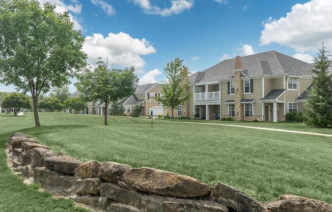 a large stone building with a grassy field