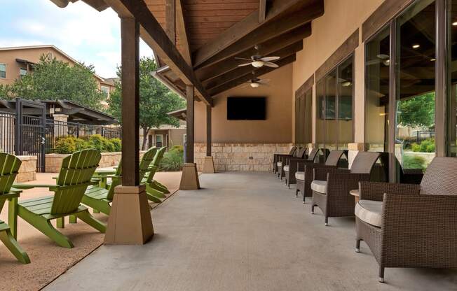 an outdoor patio with chairs and tables and a ceiling fan