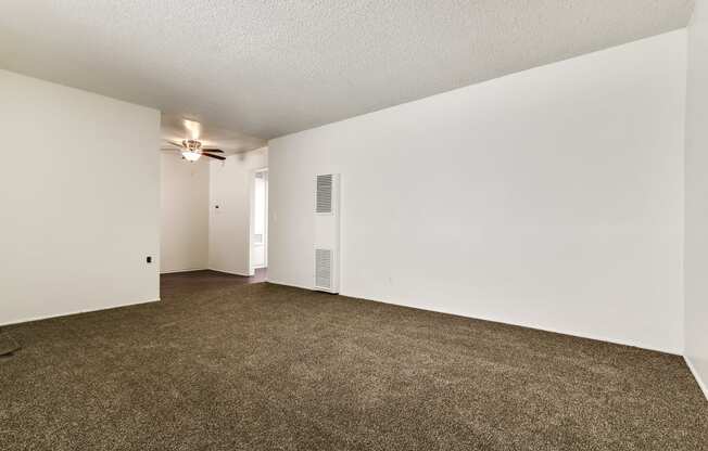 Living room with air conditioning, carpeted floors, and wood style floors in dining area