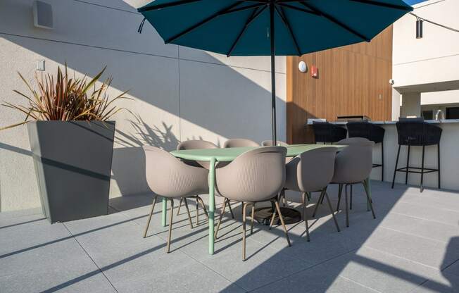 a terrace with a table and chairs and an umbrella