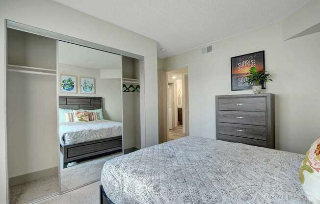 A bedroom with a large bed and a smaller bed in the background.