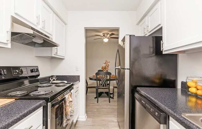A kitchen with black appliances and white cabinets.