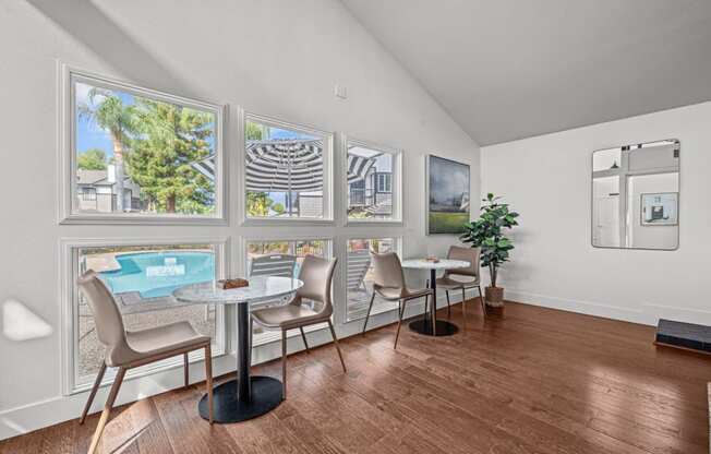 a living room with a table and chairs and a view of a pool