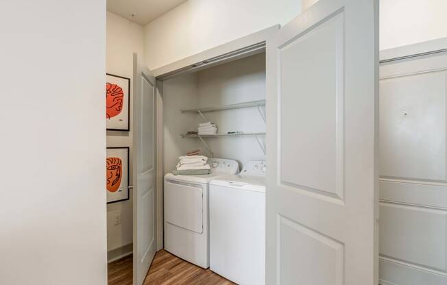 Carillon Apartments in Nashville, TN 37219 photo of a laundry room with a washer and dryer and a door to the closet