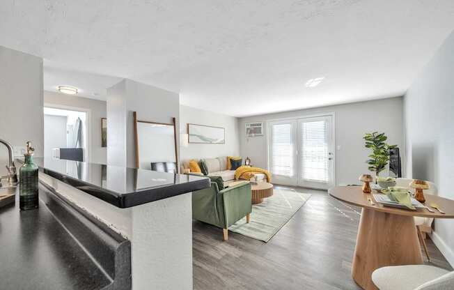 A modern kitchen with a dining area in the background.