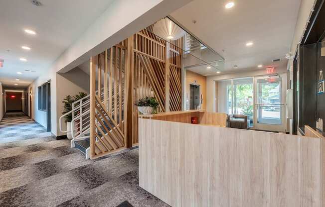 A reception area with a wooden counter and a staircase with wooden slats.
