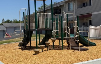 A playground with a yellow canopy and a green slide.