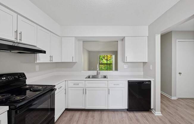 A kitchen with white cabinets and a black stove top oven.