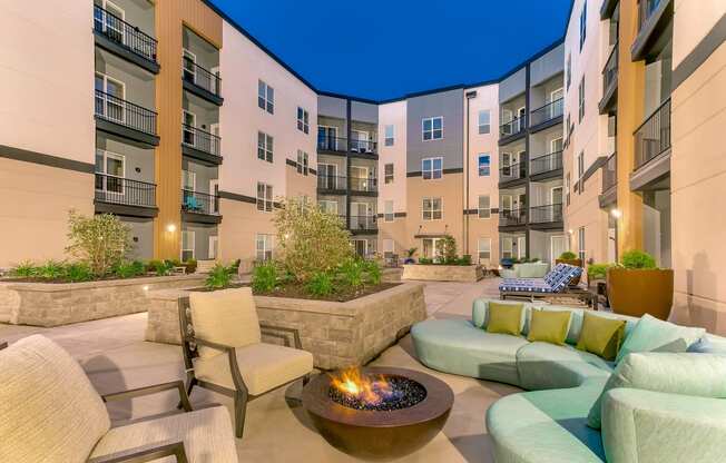 an outdoor patio with couches and chairs and a fire pit at Aster Apartments, Ohio