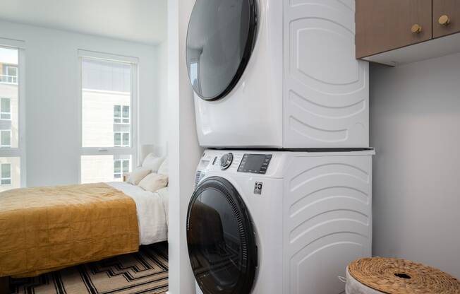 a bedroom with a washing machine and a bed with a washer and dryer at Slabtown Square Apartments, Portland