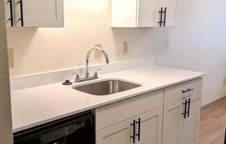 Rolling Hills Apartments upgraded kitchen with black dishwasher, white cabinets and countertops