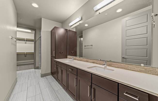 A bathroom with brown cabinets and a white sink.