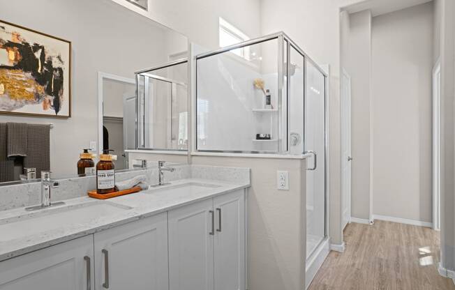 a bathroom with two sinks and a mirror and a shower