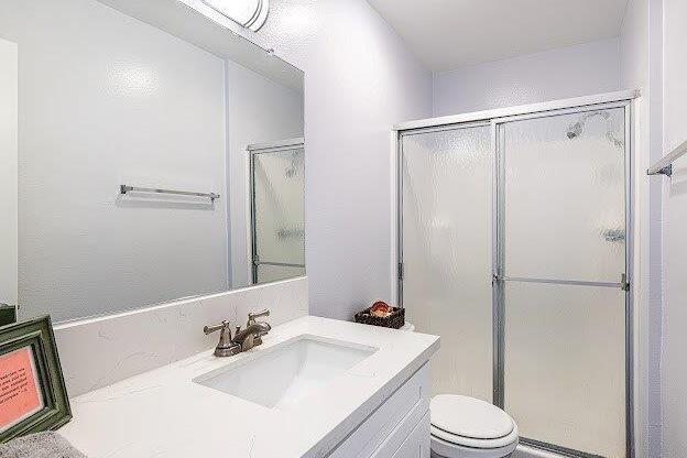 A white bathroom with a toilet, sink, and shower.