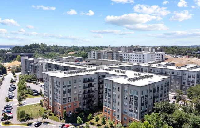 an aerial view of a group of apartment buildings with trees in the background