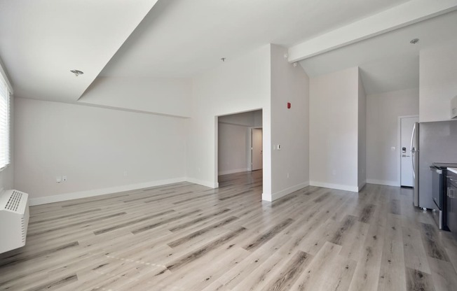a renovated living room with hardwood floors and white walls  at Track 281 Apartments, Sacramento, CA, 95811