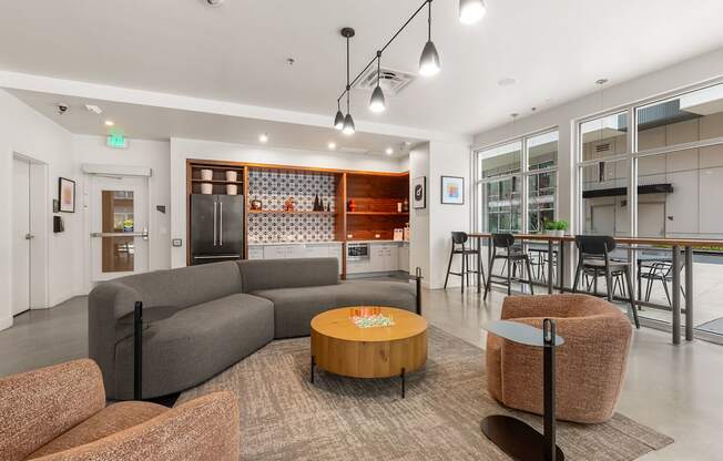 A modern living room with a grey sofa, a wooden coffee table, and a brown armchair.