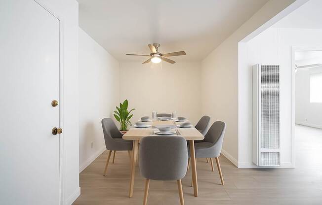 A dining room with a table set for six.