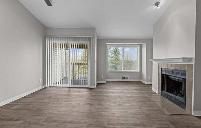 an empty living room with a fireplace and a window