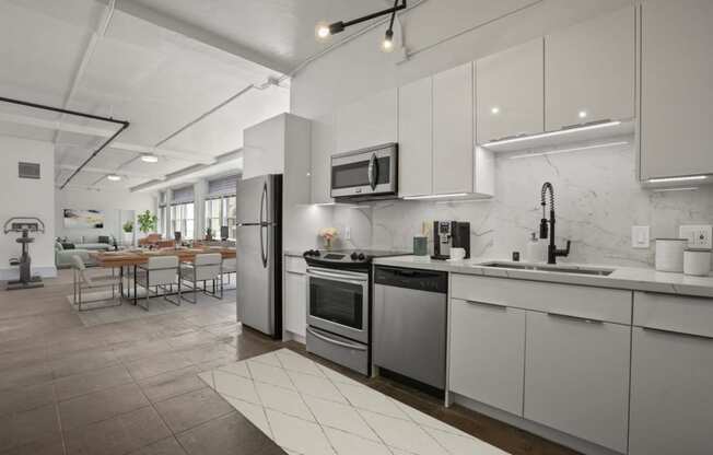 a kitchen with white cabinets and stainless steel appliances