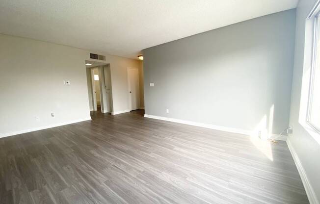 the living room of an empty apartment with wood flooring