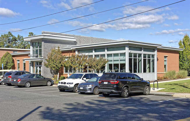 A parking lot with cars and a building in the background.