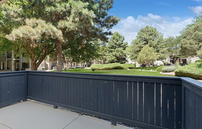 a black fence in front of a yard with trees