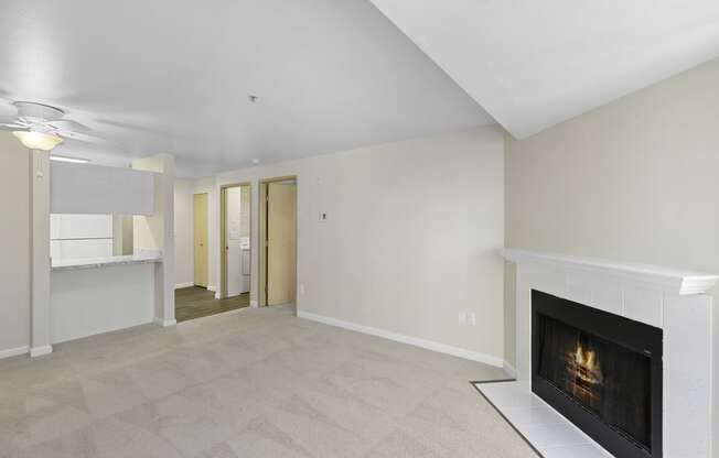 a living room with a fireplace and a kitchen in the background at Casa Blanca Apartment Homes, Everett, WA, 98204