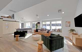 A living room with a green couch and a wooden floor.