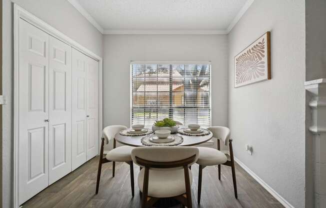A dining room with a table set for four.