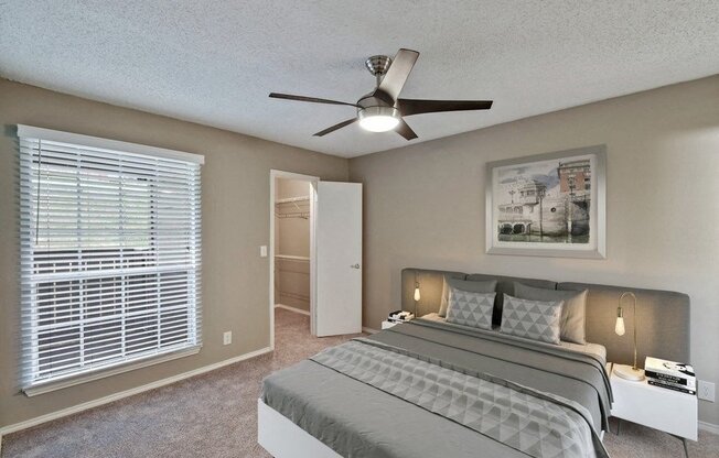 Model bedroom, carpet, bedroom door, window, and ceiling fan.